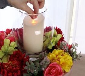 how to make a stunning front porch planter idea for spring, Placing a battery powered candle into the glass lantern
