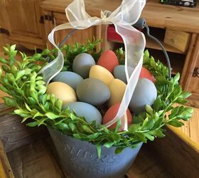 how to get easter egg dye off skin without harsh chemicals, basket of dyed easter eggs and greenery
