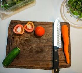 how to clean a wood cutting board disinfect it and lift pesky stains, dark wood cutting board with knife and cut vegetables on it