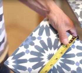 how to tile over tile the right way, person measuring width of patterned tile
