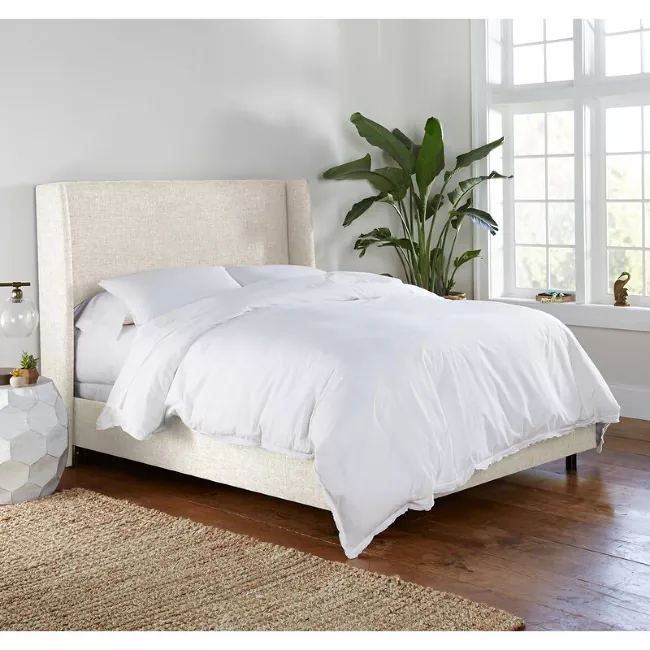 how to make your bed like a hotel, white bed with tan fabric bed frame
