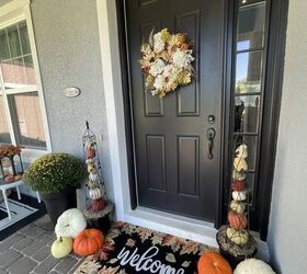 cmo hacer obeliscos de calabaza, Un porche decorado con dos obeliscos de calabaza calabazas variadas una momia una alfombra de bienvenida y una corona