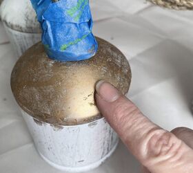 campana rstica de pottery barn, Un dedo aplicando oro a una campana para crear una campana de hierro r stica de Pottery Barn