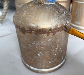 campana rstica de pottery barn, Un pincel aplicando pintura marr n sobre una campana para crear una campana de hierro r stica de Pottery Barn