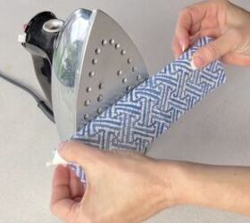 She rolls a napkin around a candle and holds it against an iron for THIS