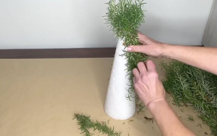 3 easy citrus dcor ideas to upgrade your home for the holidays, Using floral pins to attach long stalks of rosemary to a Styrofoam cone
