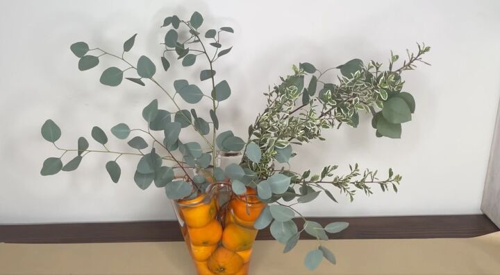 3 easy citrus dcor ideas to upgrade your home for the holidays, Greenery added to a vase filled with oranges