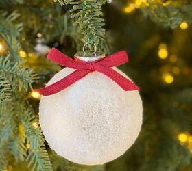 adornos navideos diy, Adorno de bola de rbol de Navidad nevado con un lazo rojo en el rbol