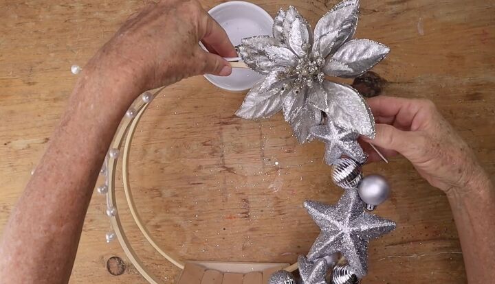 5 simple steps to make a stunning embroidery hoop centerpiece, Securing a silver faux flower to the top of an embroidery hoop