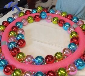 a breathtaking jumbo christmas ball wreath in 3 easy steps, Gluing a second layer of Christmas balls to the inner circle of the pool noodle wreath form