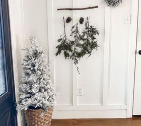 Colgador de invierno con tallos de cedro y piñas