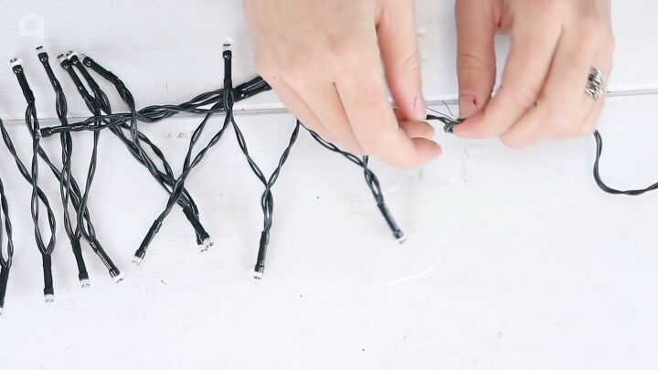 christmas decor how to make a beautiful diy ornament garland, Sliding the hook over a section of the wire of the string light
