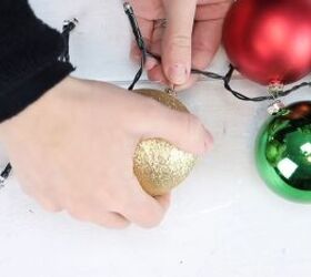 christmas decor how to make a beautiful diy ornament garland, Alternating the colors of Christmas ornaments on either side of the light garland