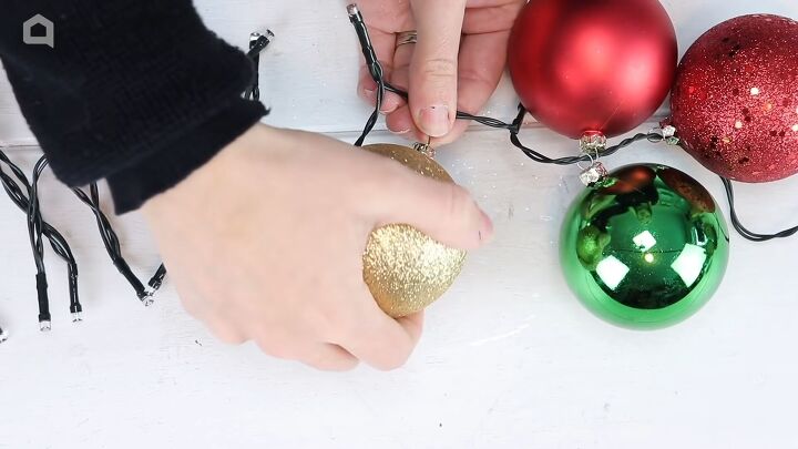christmas decor how to make a beautiful diy ornament garland, Alternating the colors of Christmas ornaments on either side of the light garland