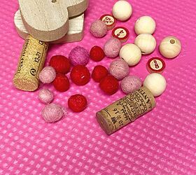 borlas de madera con forma de corazn, cuentas y corazones en bandeja rosa