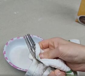 7 money saving cornstarch cleaning hacks for a spotless home, Polishing a silver fork with a cloth dipped in a cornstarch and water solution