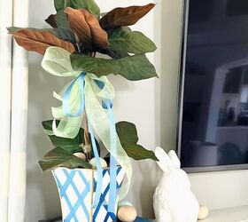 topiario de corazones diy para una vieta de san valentn, Este topiario DIY de ramas de magnolia est decorado para Pascua en un macetero azul y blanco pintado a mano