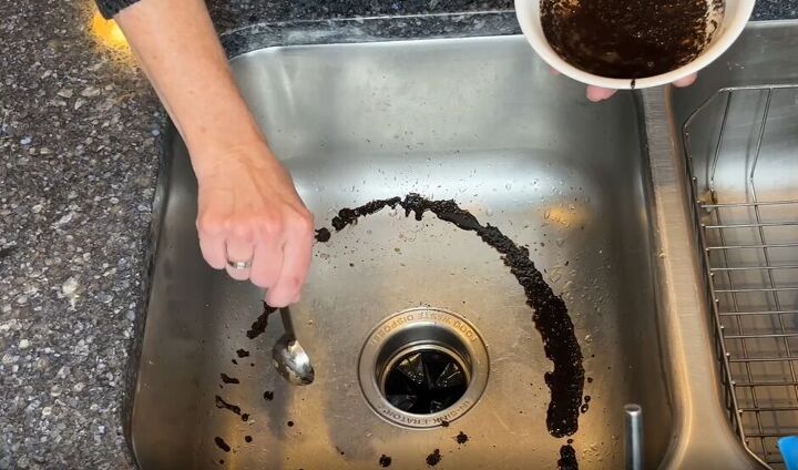 7 astonishing coffee grounds hacks to save you time and money, Coffee grounds being spread around a stainless steel sink