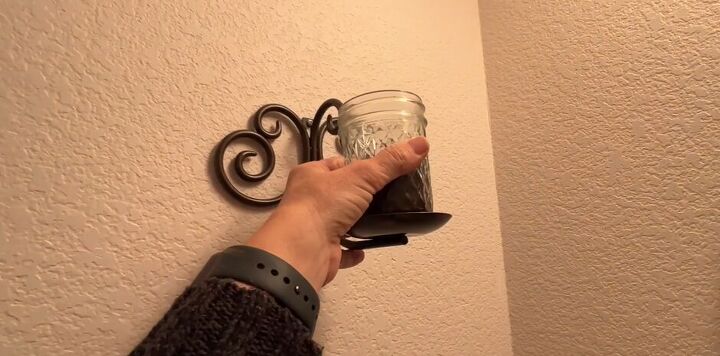 7 astonishing coffee grounds hacks to save you time and money, Jar of coffee grounds being placed on a holder in the bathroom