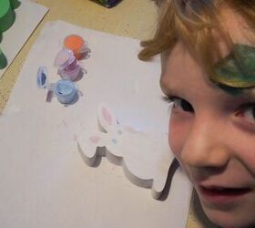 ensee a su hijo a pintar un conejo de pascua de madera