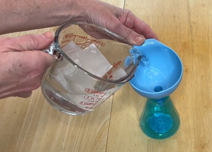 6 dryer sheet hacks the secret to effortless cleaning, Pouring a dryer sheet and water mixture through a funnel into a spray bottle