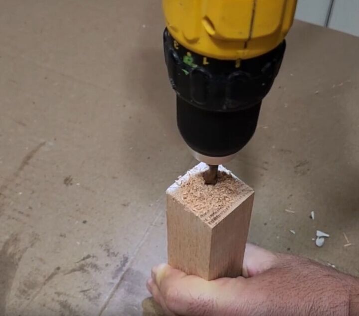 how to make an impressive rustic diy wood crate coffee table, Drilling through the center of a piece of wood