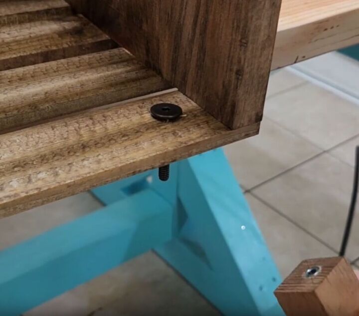 how to make an impressive rustic diy wood crate coffee table, A dark bolt inserted into the drilled hole for the legs