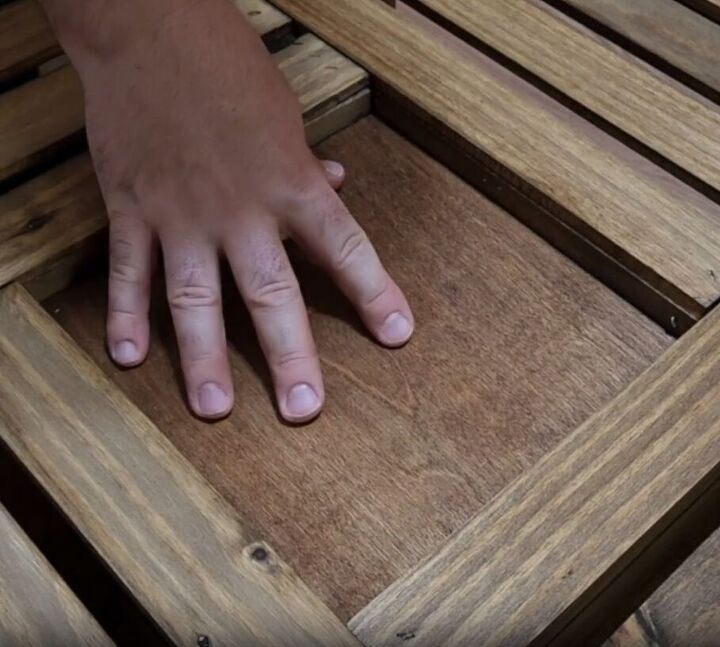 how to make an impressive rustic diy wood crate coffee table, Placing a square wood piece into the center of the coffee table