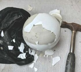esfera de jardn de hormign fcil de hacer, Un globo de cristal que cubre hormig n curado con muchos trozos rotos en fragmentos con un trapo al lado