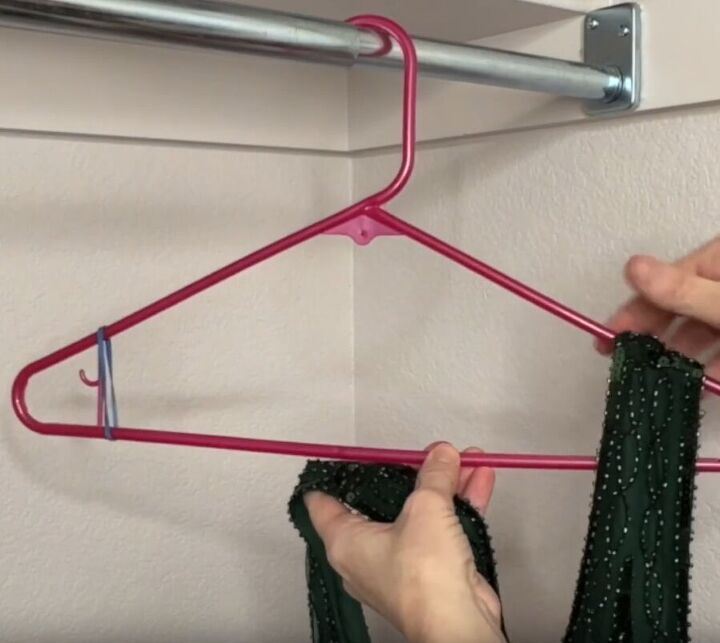 12 amazing hanger hacks to keep your home organized, Placing a dress onto a plastic hanger with rubber bands on each side