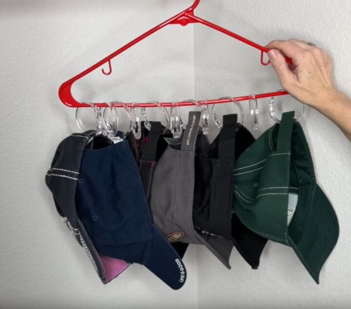 12 amazing hanger hacks to keep your home organized, Caps hanging from shower curtain rings attached to a hanger
