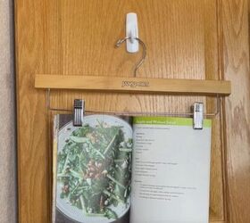 12 amazing hanger hacks to keep your home organized, An open recipe book clipped onto a pants hanger on a Command hook