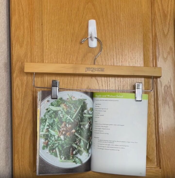 12 amazing hanger hacks to keep your home organized, An open recipe book clipped onto a pants hanger on a Command hook