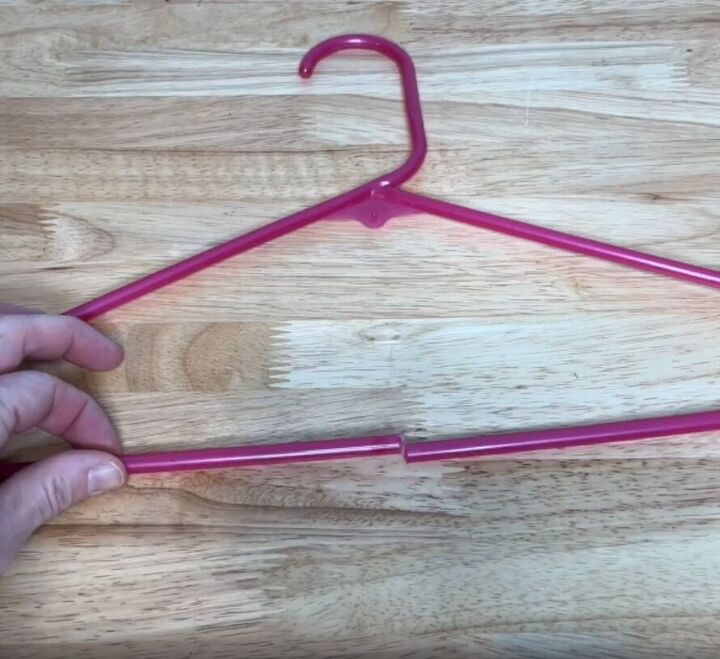 12 amazing hanger hacks to keep your home organized, A plastic hanger with a cut in the bottom center