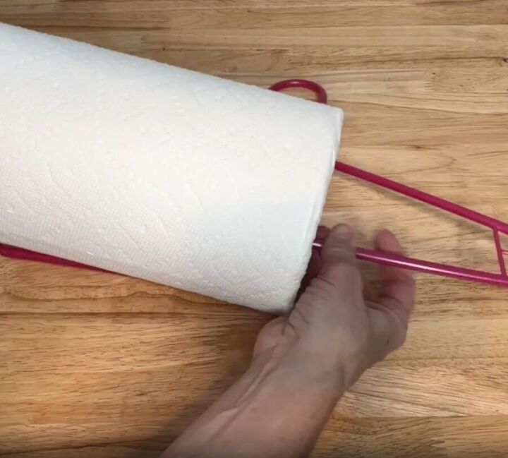 12 amazing hanger hacks to keep your home organized, Sliding a roll of paper towel onto a plastic hanger