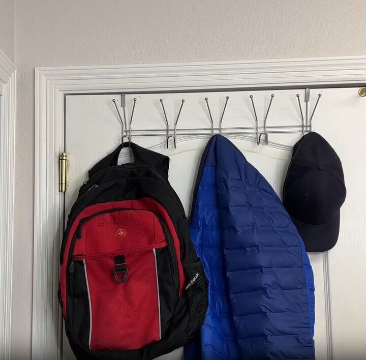 coat closet organization how to organize yours like a pro, An over the door rack with a backpack coat and hat hanging from it