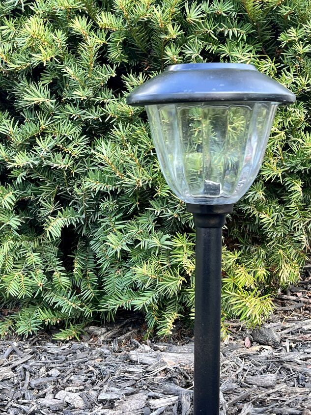 the best way to restore outdoor solar pathway lights, A painted solar light nestled among a green evergreen bush
