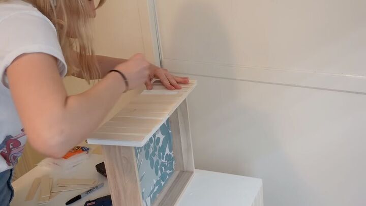how to transform a diy makeup vanity into a colorful art deco piece, Gluing the craft sticks to the vanity drawer fronts