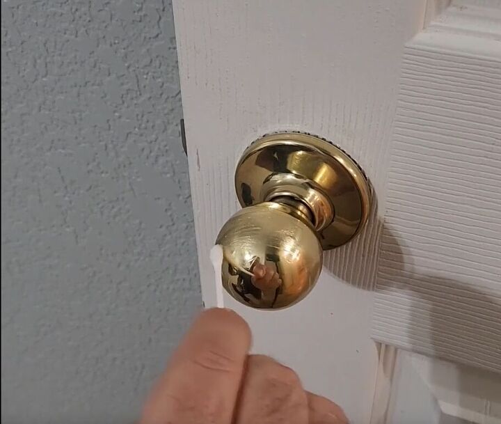 handyman tips 8 home improvement hacks to make your life easier, Spreading Vaseline onto a door handle with a Q tip