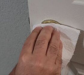 handyman tips 8 home improvement hacks to make your life easier, Wiping paint off a doorknob with a paper towel