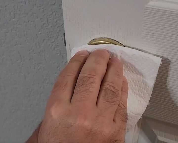 handyman tips 8 home improvement hacks to make your life easier, Wiping paint off a doorknob with a paper towel