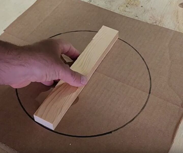 10 easy steps to build your own diy outdoor plant stands, Laying a 10 inch wood strip in the middle of a circle drawn on cardboard