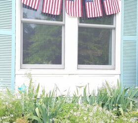 bandera diy por liberty, cinco banderas colgadas delante de las ventanas de una casa con un macizo de flores debajo