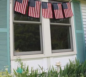 bandera diy por liberty, cinco banderas colgadas delante de las ventanas de la casa con un macizo de flores debajo