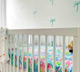 cmo instalar una pared decorativa de calcomana removible en el cuarto del beb, pared blanca con pegatinas de palmeras verde azulado cuna blanca con s banas de colores delante de la pared