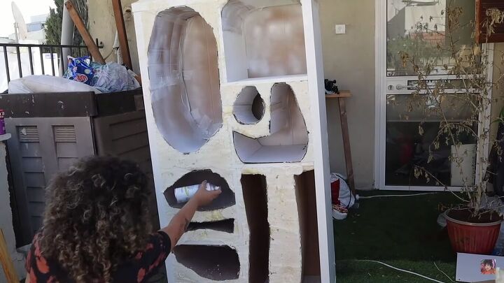 Spray-painting the brown cardboard white