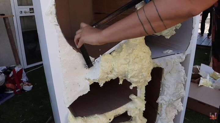 Cutting off the excess foam with a hand saw