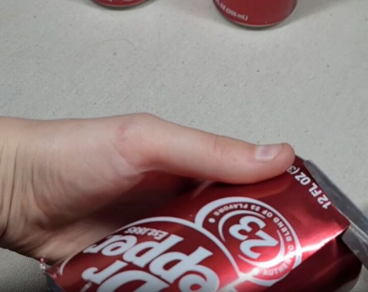 Trim off the bottom of the soda can with scissors