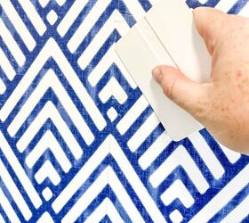 cmo colgar papel pintado removible, mano sujetando una herramienta para alisar papel pintado us ndola para alisar arrugas en el papel pintado