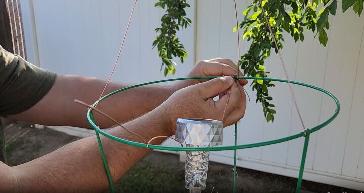 Attaching the solar light to the chandelier with copper wire